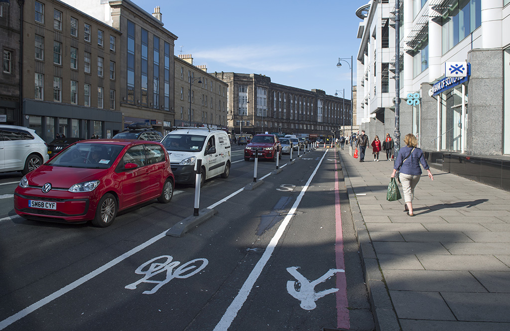 Black and white stripped cylinders mounted in kerb-like bases separate motor traffic and a cycle lane on Lothian Road