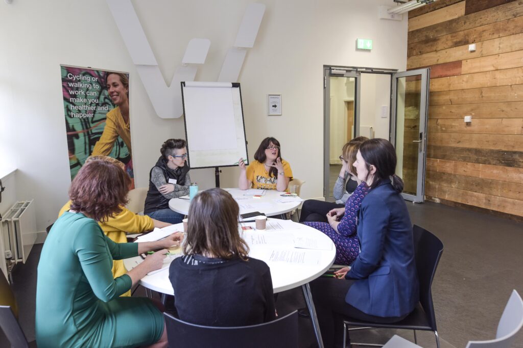 People in a discussion while sitting around a table in a meeting